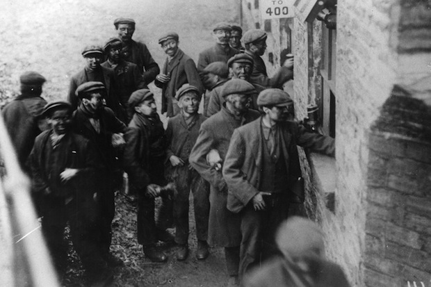 Hard-bitten men standing idle